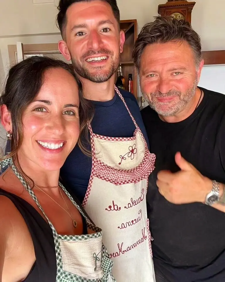 Fabrizio and two guests enjoy a cooking class in Italy: The three people smile for a selfie, wearing aprons, possibly during an Italian cooking class or culinary tour. Ideal for promoting cooking classes and food tours in Italy with Fabrizio.