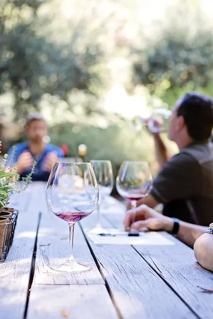 Tuscan wine tasting experience: People enjoying red wine at an outdoor table with wine glasses and notes. Ideal for promoting wine tours and culinary experiences in Tuscany.